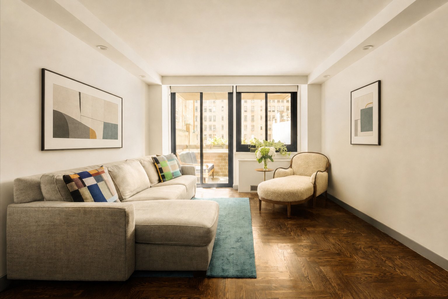 The living room of Residence 6E, artwork on the walls and south light through the glass doors to the terrace