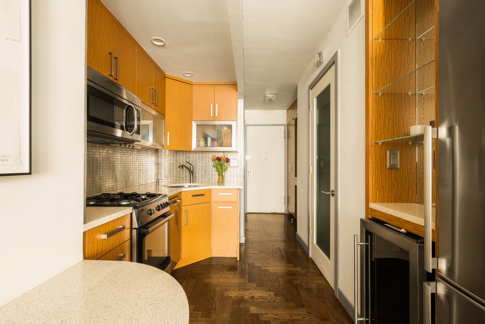 The renovated kitchen: quartz counters, stainless appliances, and the built-in wine refrigerator