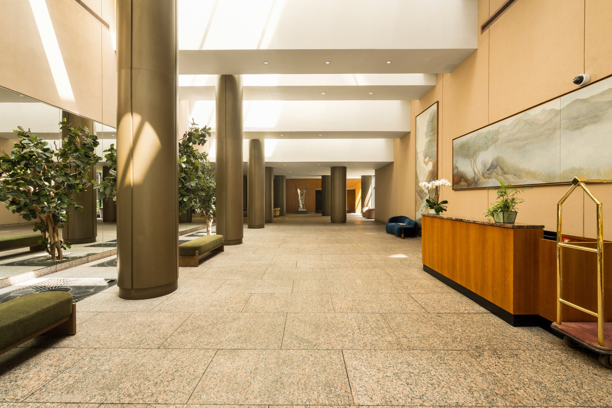The renovated lobby of The Colonnade, with its columns, planted garden, and concierge desk