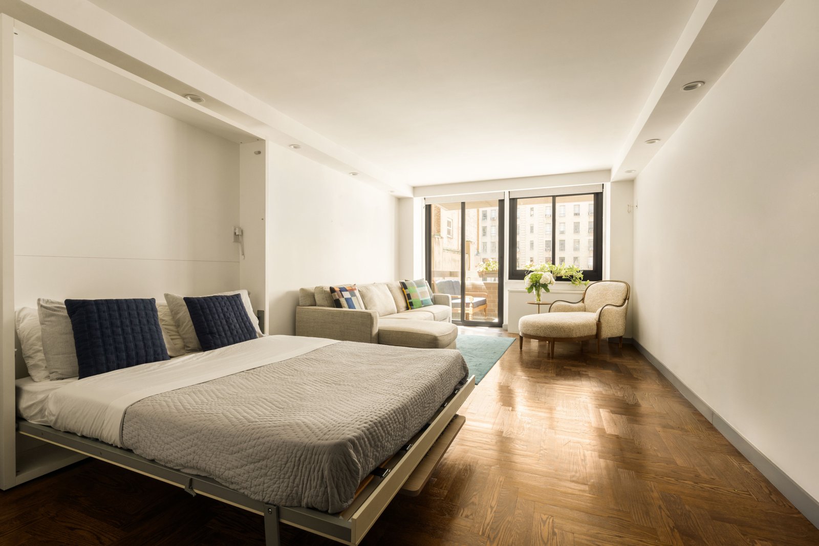 The Murphy bed lowered, with the living area and terrace beyond